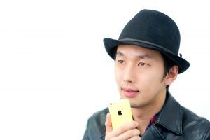 スマホに自分のスピーチを録音する男性